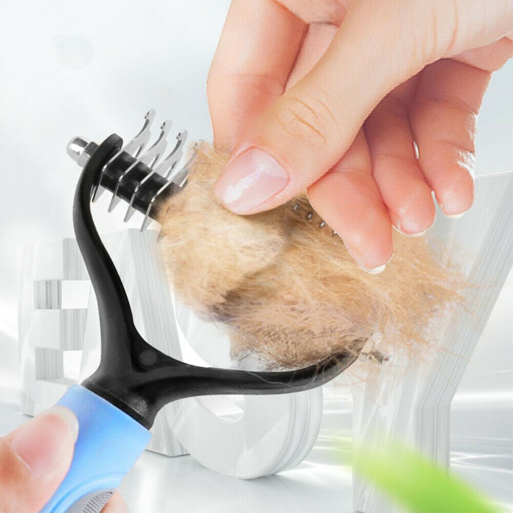 Blue dematting comb head held by hand showing collected pet fur clump