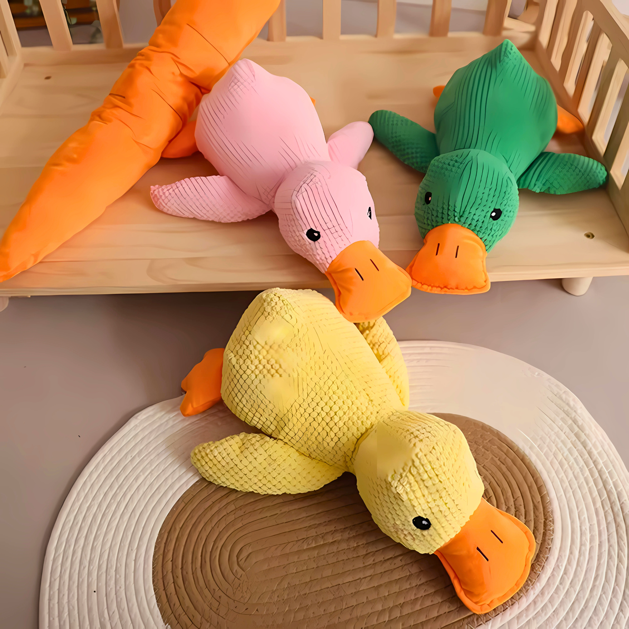 Yellow, pink and green Calming Duck Toys displayed on a wooden shelf and woven mat with a carrot plush toy