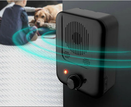 Black Dog Bark Silencer close-up with red LED and dial, dog in background
