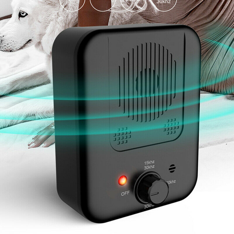 Black Dog Bark Silencer front view emitting teal waves, husky in background